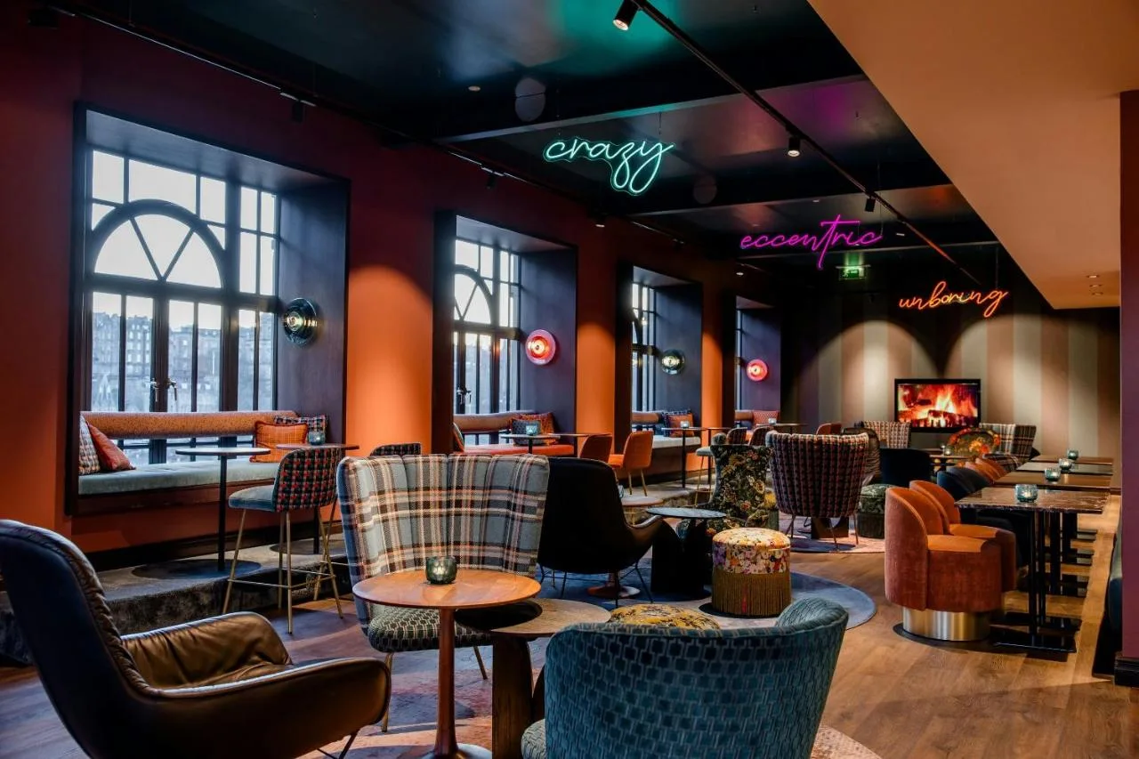a restaurant with chairs and tables and a bar at Motel One Edinburgh-Princes in Edinburgh