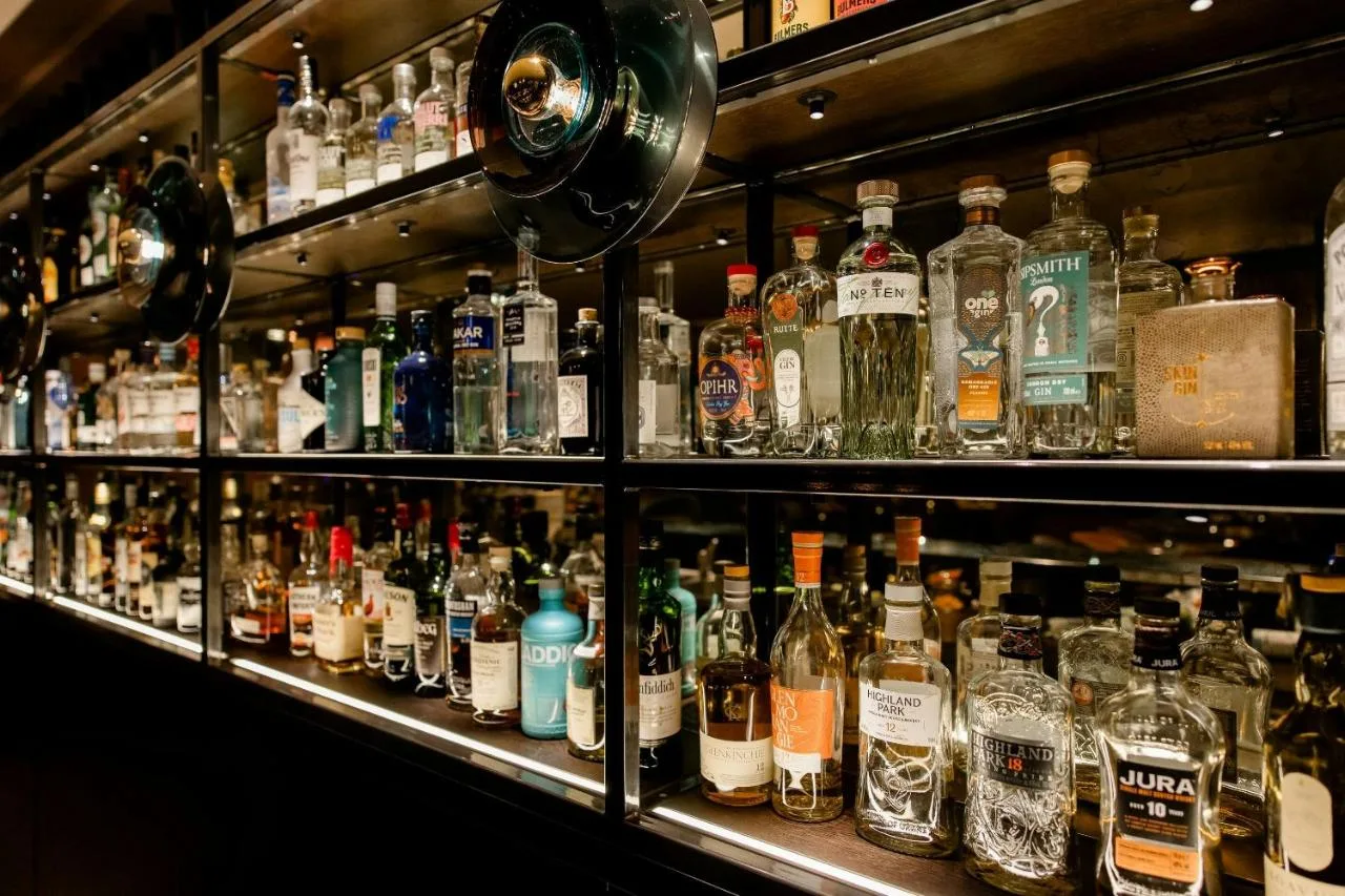 a shelf filled with lots of bottles of alcohol at Motel One Edinburgh-Princes in Edinburgh